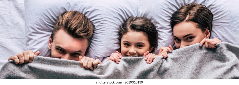 The Happy Family Laying Under The Blanket