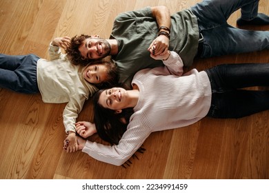 Happy family with a little girl lying on the floor - Shutterstock ID 2234991459