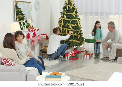 Happy Family In Living Room Decorated For Christmas