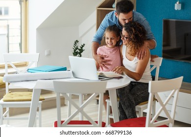 Happy family in living room. Mother calculate home budget and savings,while her husband and daughter support her with group hug. - Powered by Shutterstock