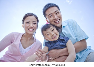 	Happy Family Looking At Camera In Park	