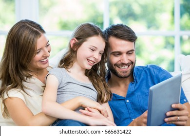 Happy Family Looking At Digital Tablet In House