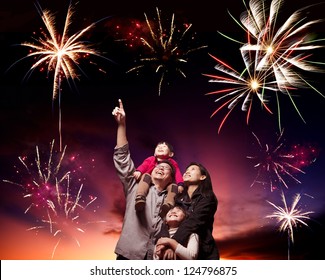 Happy Family Looking Fireworks In The Evening Sky