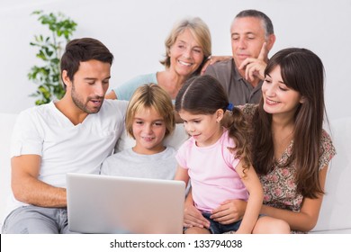 Happy Family Looking At Laptop On The Couch