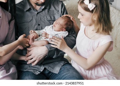 happy family looking at a newborn yawning baby.