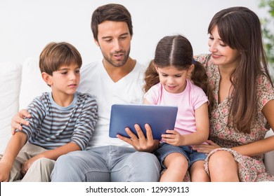 Happy Family Looking At Tablet Pc On The Couch