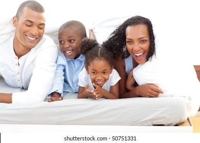 Happy Family Lying Down On Bed