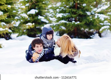 Happy Family Lying On The Snow In Winter Forest, Horizontal Photo