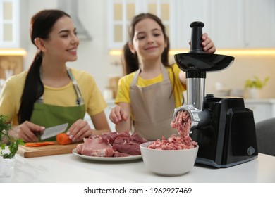 Happy Family Making Dinner Together In Kitchen, Daughter Using Modern Meat Grinder While Mother Cutting Carrot