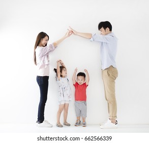 Happy Family Making The Home Sign  Before White Wall
