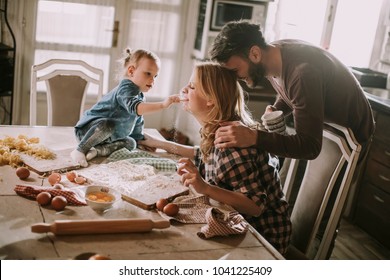 Happy Family Making Pasta In The Kitchen At Home