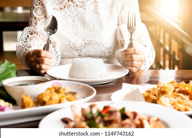 Happy Family Meal With Full Food On Table Asian Elder Mother Hand Holding Fork, Knife, Rice On Plate & Table. Enjoy True Authentic Exotic Homemade Healthy Thai Meal With Child On Holidays Thanksgiving