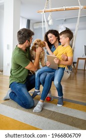 Happy Family With Modern Devices And Dog Having Fun, Playing At Home