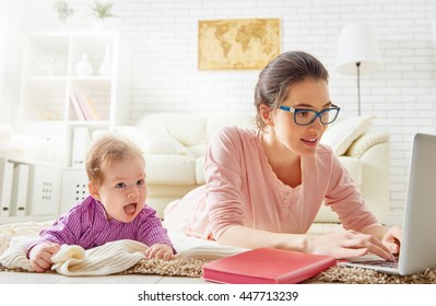 Happy Family. Mom And Baby. A Young Mother Working With Laptop At Home