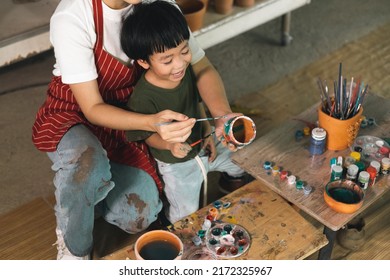 Happy family moment Mother teaching son how to painting mug cup ceramic workshop. Child creative activities and art. Kid playing  pottery workshop. Developing children's learning skills. - Shutterstock ID 2172325967