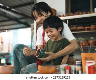 Happy family moment Mother teaching son how to painting mug cup ceramic workshop. Child creative activities and art. Kid playing  pottery workshop. Developing children's learning skills. - Powered by Shutterstock