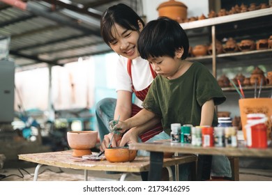 Happy family moment Mother teaching son how to painting mug cup ceramic workshop. Child creative activities and art. Kid playing  pottery workshop. Developing children's learning skills. - Powered by Shutterstock