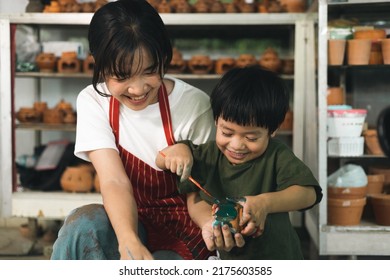 Happy family moment Mother teaching son how to painting mug cup ceramic workshop. Child creative activities and art. Kid playing  pottery workshop. Developing children's learning skills. - Powered by Shutterstock