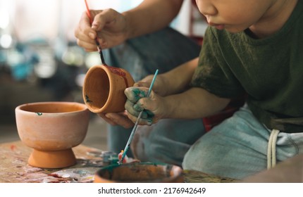 Happy family moment Mother teaching son how to painting mug cup ceramic workshop. Child creative activities and art. Kid playing  pottery workshop. Developing children's learning skills. - Powered by Shutterstock