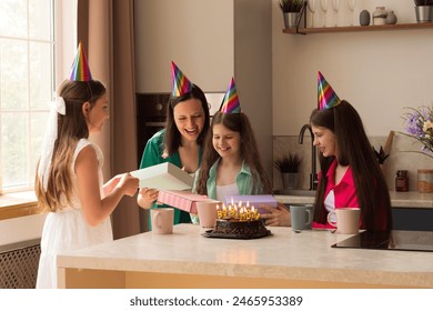 Happy family moment as a young girl opens birthday presents at home. Essence and emotions of the birthday celebrations, atmosphere of joy and family bonding

 - Powered by Shutterstock