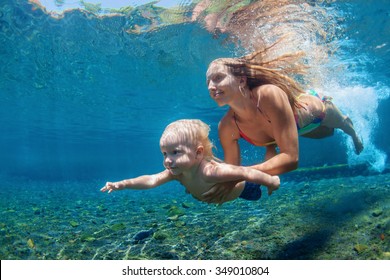 Happy Family - Mother With Baby Boy Dive Underwater With Fun In Sea Pool. Healthy Lifestyle, Active Parent, People Water Sport Outdoor Activity And Swimming Lessons On Beach Summer Holidays With Child