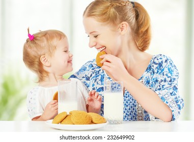 Happy Family Mother And Baby Daughter  Child Girl At Breakfast: Biscuits With Milk