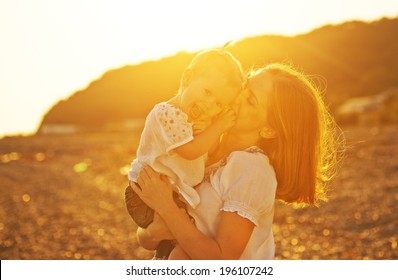 Happy Family. Mother And Baby Girl Daughter On Beach At Sunset In Nature