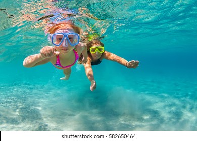 Happy family - mother with baby girl dive underwater with fun in sea pool. Healthy lifestyle, active parent, people water sport outdoor adventure, swimming lessons on beach summer holidays with child