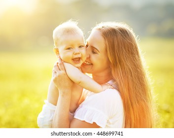 Happy Family Mother And Baby Hugging And Kiss In Summer On The Nature