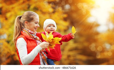 Happy Family Mother And Baby Laugh With Leaves In Nature Autumn