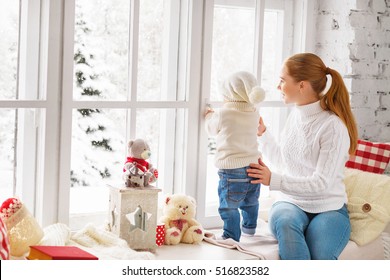  Happy Family Mother And Baby Look Out The Window For The Winter Christmas