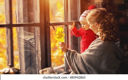 Happy Family Mother And Baby Playing And Laughing At The Window In The Fall