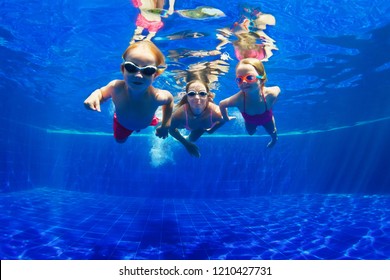 Happy Family - Mother, Baby Son, Daughter In Goggles Swim, Dive In Pool With Fun - Jump Deep Down Underwater. Healthy Lifestyle, People Water Sport Activity, Swimming Lessons On Holidays With Kids