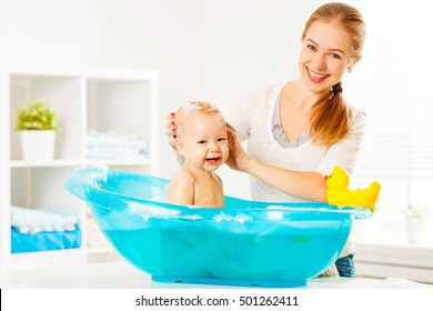 Happy Family Mother Bathes The Baby In A Blue Bath