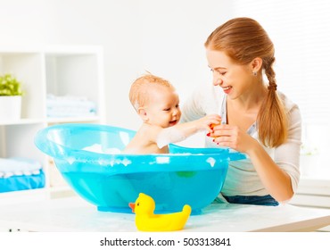 Happy Family Mother Bathes The Baby In A Blue Bath