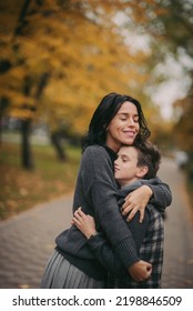 Happy Family: Mother And Child Cuddling On Autumn Walk In Nature Outdoors