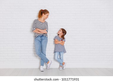 happy family mother and child daughter near an empty brick wall