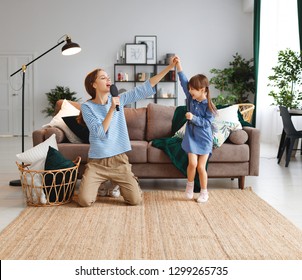 Happy Family Mother And Child Daughter Play At Home And Sing With Combs
