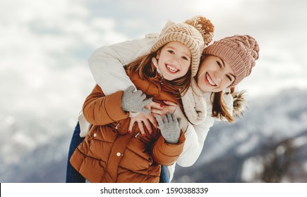 Happy Family Mother And Child Daughter Playing And Hugging  On A Winter Walk
