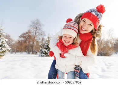 Happy Family Mother And Child Daughter Having Fun, Playing At Winter Walk Outdoors