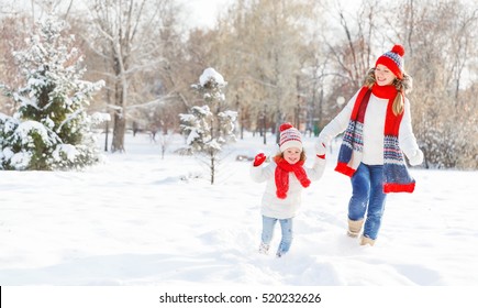 Happy Family Mother And Child Daughter Having Fun, Playing At Winter Walk Outdoors