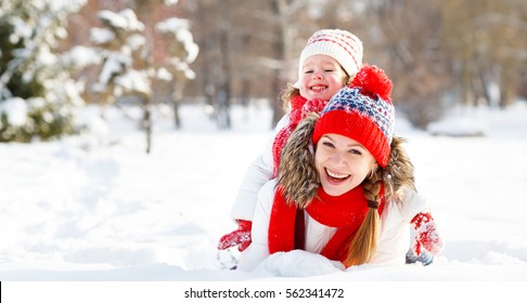 Happy Family Mother And Child Daughter Playing And Hugging  On A Winter Walk
