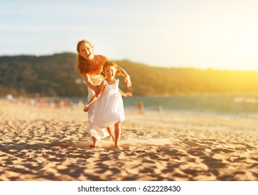 Happy Family  Mother And Child Daughter Run, Laugh And Play At Beach