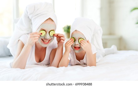 Happy Family Mother And Child Daughter Make Face Skin  Mask With Towel On Head
