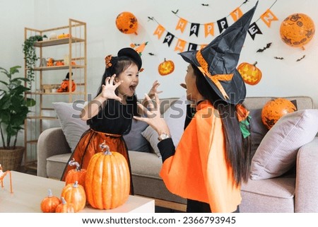 Happy family mother and child happy girl with Halloween at home together beautifully decorated. Mother teasingly playing with daughter