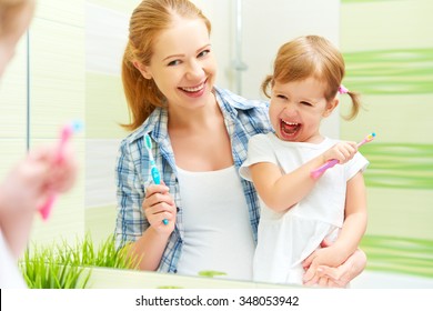 Happy Family Mother And Child Little Girl Cleans Teeth With A Toothbrush In The Bathroom