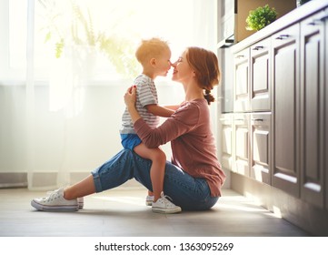 Happy Family Mother And Child Son Hugging In Kitchen
