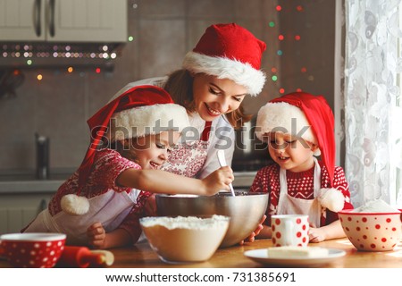 happy family mother and children son and daughter bake cookies for Christmas
