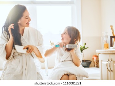 Happy family! Mother and daughter child girl are combing hair in the bathroom. - Powered by Shutterstock