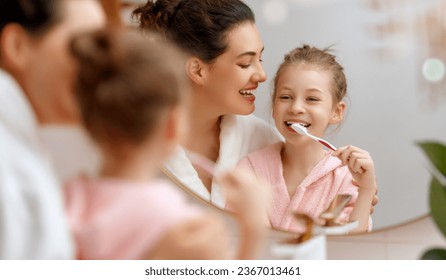 Happy family! Mother and daughter child girl are brushing teeth toothbrushes in the bathroom. - Powered by Shutterstock